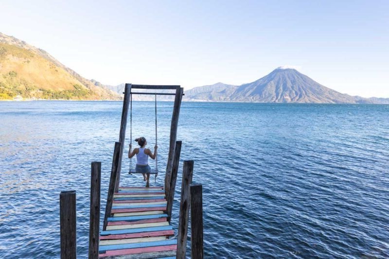 Woman on swing at jetty on Lake Atitlan in Guatemala