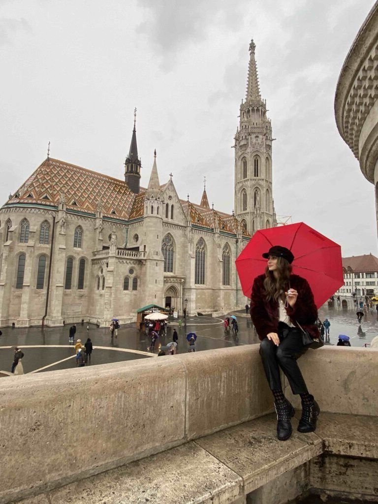 Woman holding a red umbrella on a rainy day in Budapest