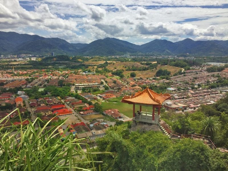 View over the landscape in Malayisa with a lookout tower and mountains in the distance