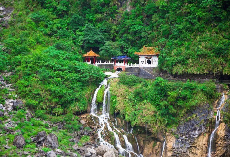 one of the temples in taroko gorge with waterfall cascading below it