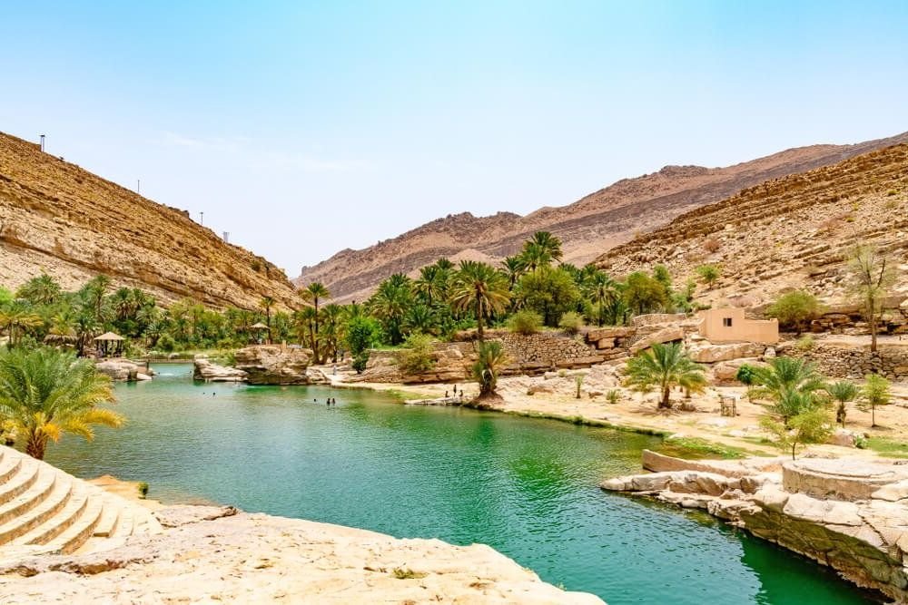 Wadi Bani Khalid in Oman, with beautiful blue water in this desert oasis and palm trees